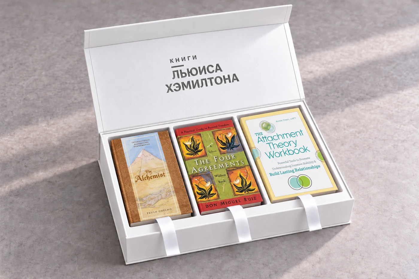 Открытая белая коробка с тиснением «Книги Льюиса Хэмилтона» и тремя книгами