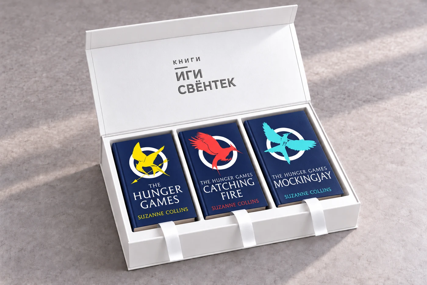 Открытая белая коробка с тиснением «Книги Иги Свёнтек» и тремя книгами