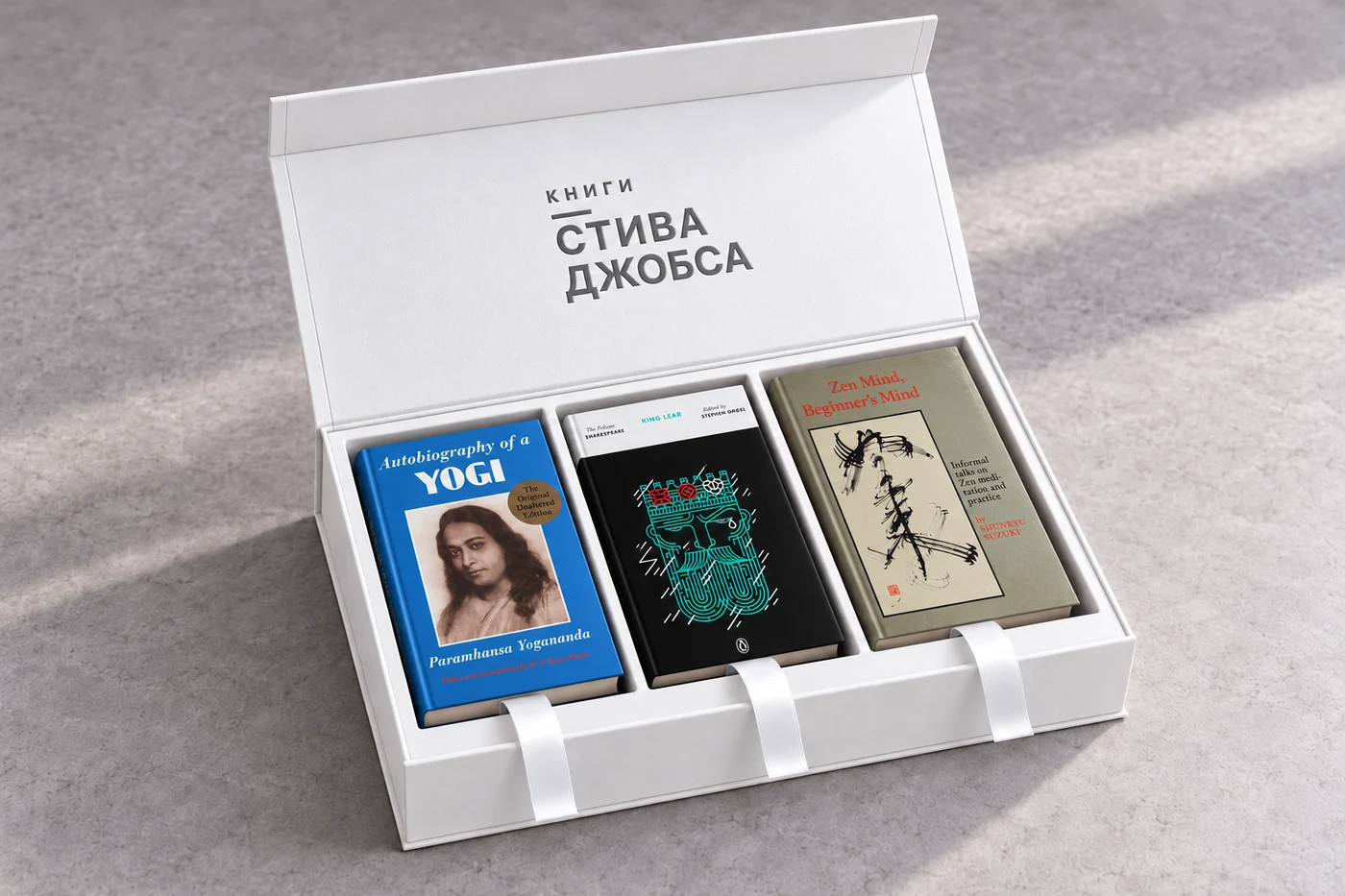 Открытая белая коробка с тиснением «Книги Стива Джобса» и тремя книгами
